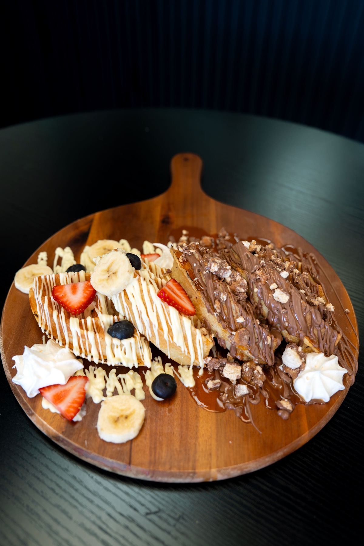 Belgian waffle covered in fruit and chocolate
