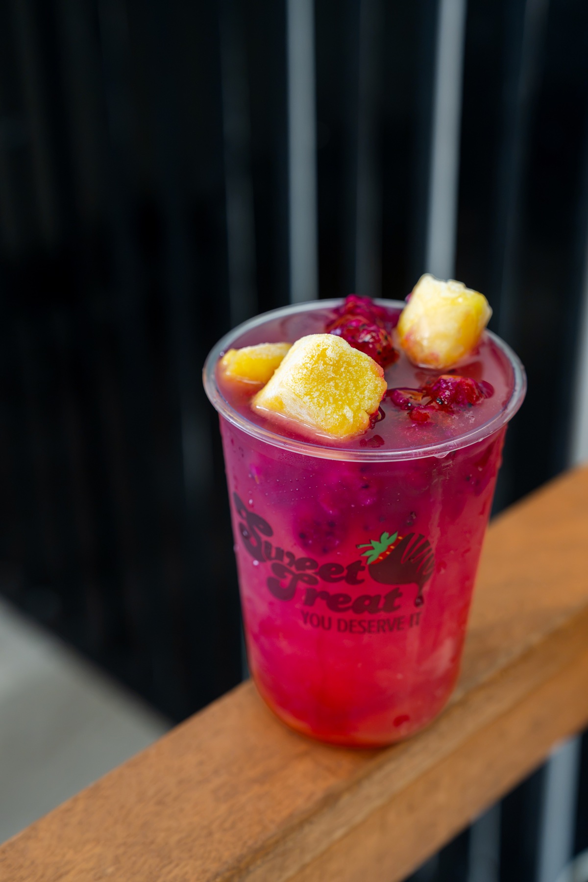 Pink dragon fruit drink with mango and berries in a Sweet Treat cup